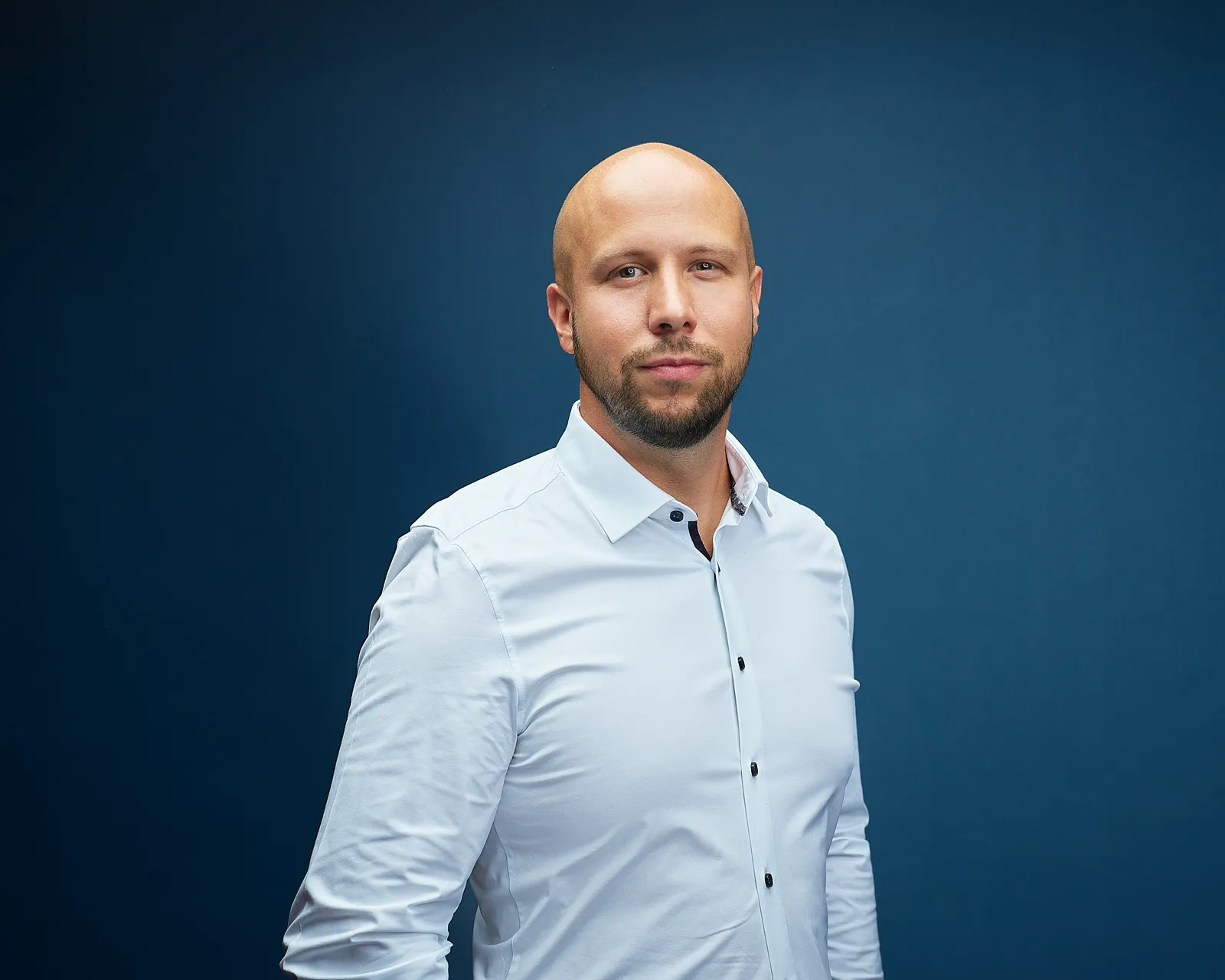 HKCM-Mitarbeiter im Seitenprofil vor blauem Hintergrund