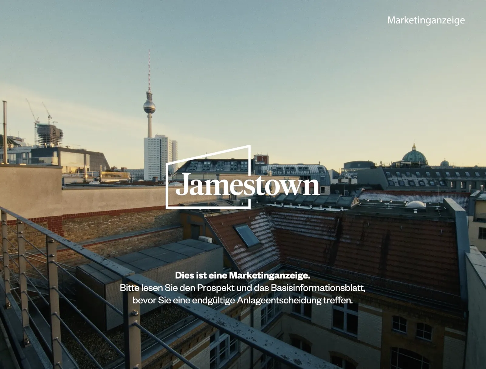 Abendlicher Blick über Berliner Dächer mit Fernsehturm, davor das Jamestown-Logo